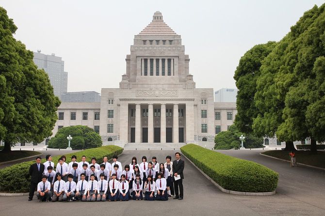 国会議事堂前で写真を撮る修学旅行グループ