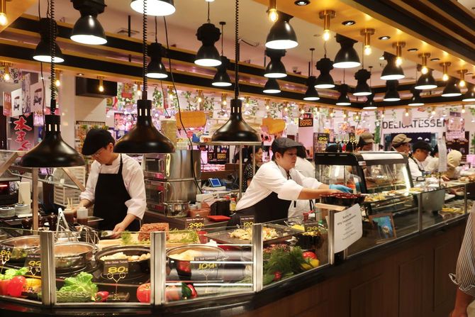 店内の本格的な調理場で料理を出すスタッフたち