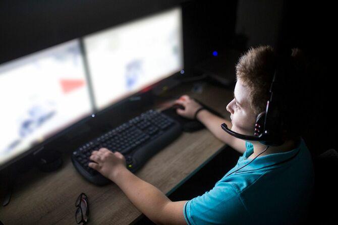 自宅でコンピュータ上でゲームをしている男の子