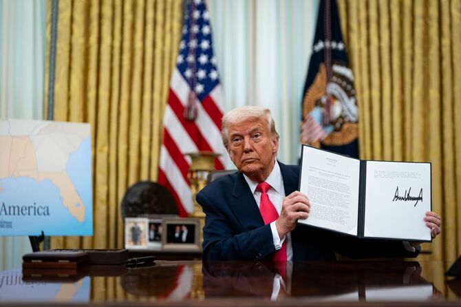 2025年3月6日、アメリカ・ワシントンD.C.のホワイトハウスの執務室で、署名された大統領令を掲げるドナルド・トランプ米大統領。