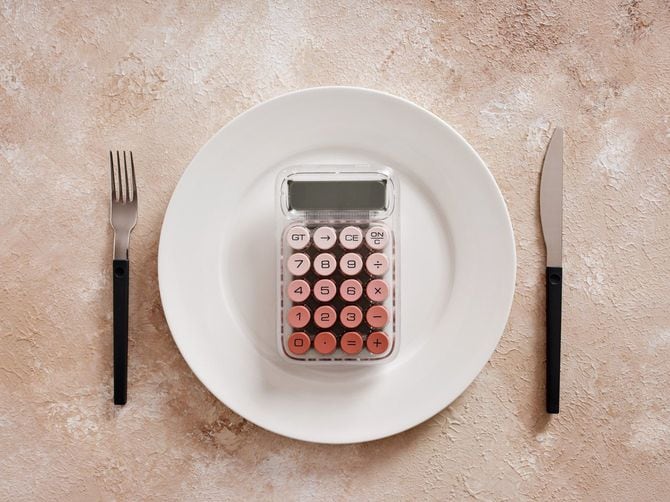 ダイエットとカロリー計算を象徴する皿に横たわる電卓