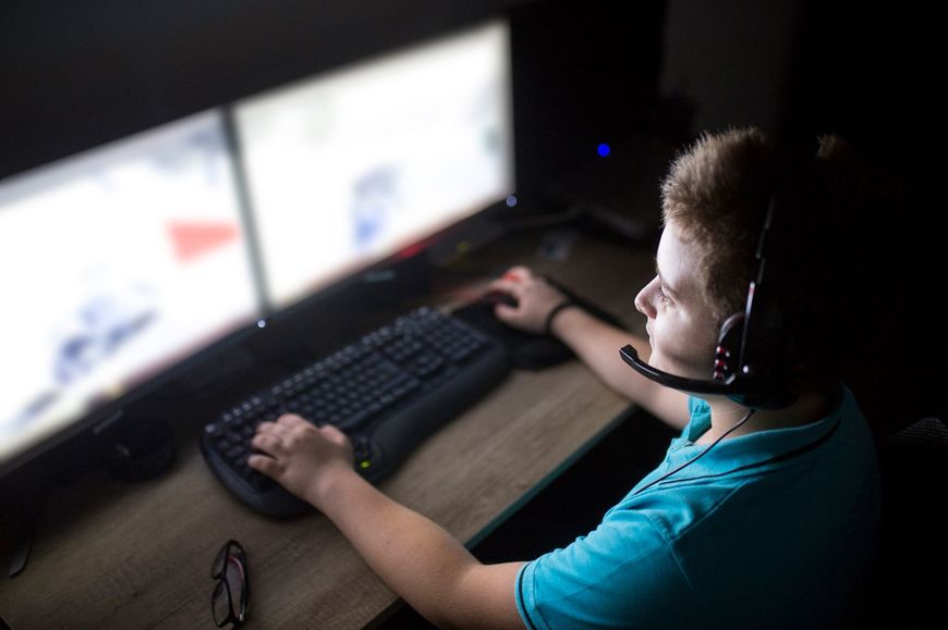 自宅でコンピュータ上でゲームをしている男の子