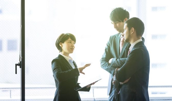 オフィスで立ち止まって話をするグループ