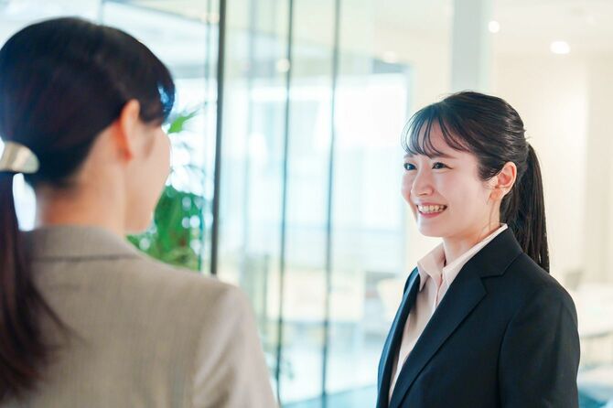 オフィスで会話する二人のビジネスウーマン