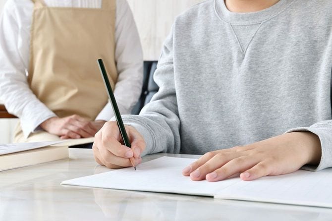 勉強をする子供を見ている母親