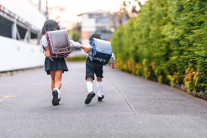 手をつないで走る日本の小学生