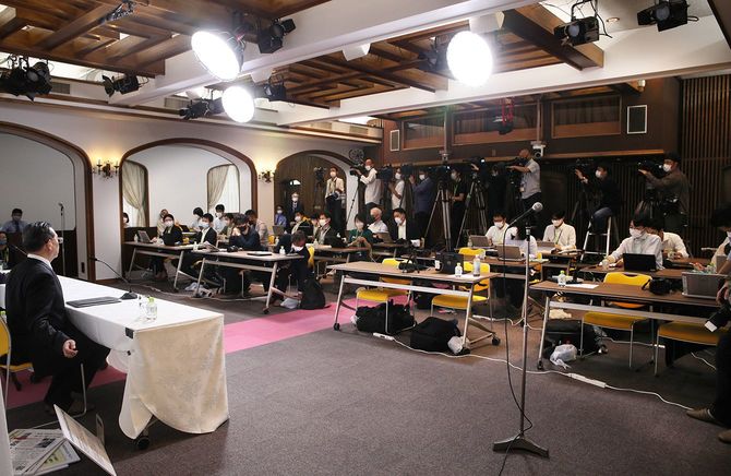 記者会見に詰めかけた多くの報道陣と記者会見する世界平和統一家庭連合(旧統一教会)の勅使河原秀行氏(左手前)ら=2022年9月22日、東京都渋谷区