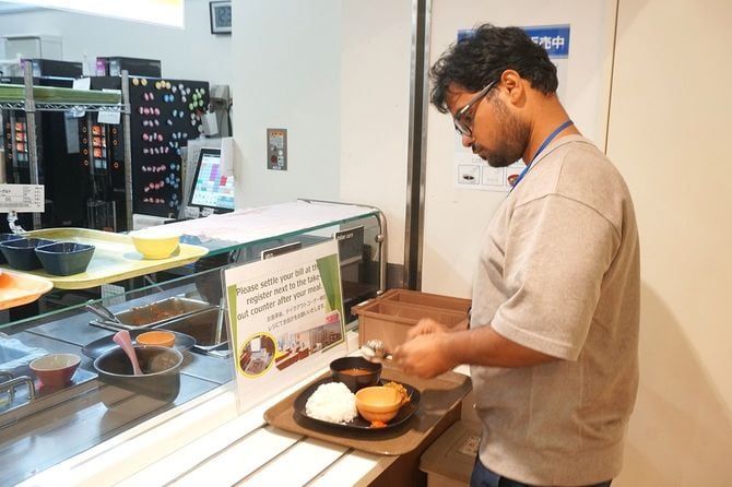 スズキの社食でベジタリアン料理を受け取るインド人従業員