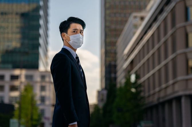 マスクをするスーツの男