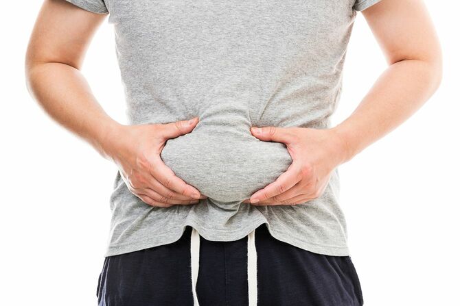 お腹の肉をつまむ男性