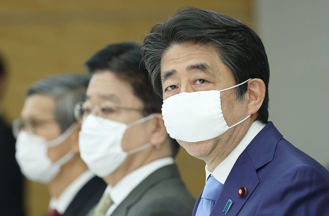 新型コロナウイルス感染症対策本部で、緊急事態宣言を5月31日まで延長することを表明する安倍晋三首相（右）