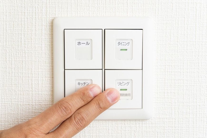 電気のスイッチに触れる手