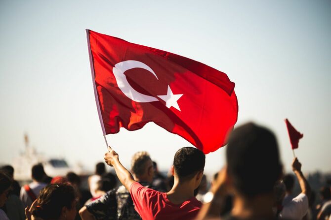 トルコ国旗を手にパレードに参加する男性