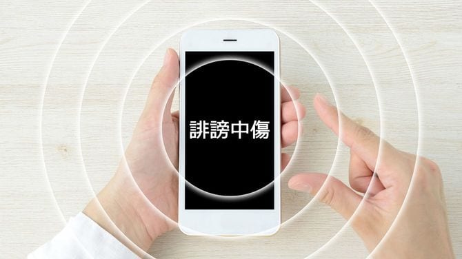 スマートフォンの画面には誹謗中傷の文字