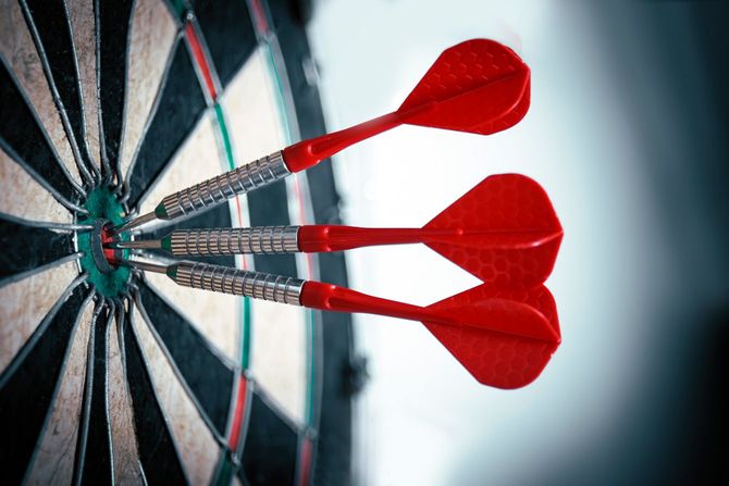 的の中心に刺さった3本のダーツ