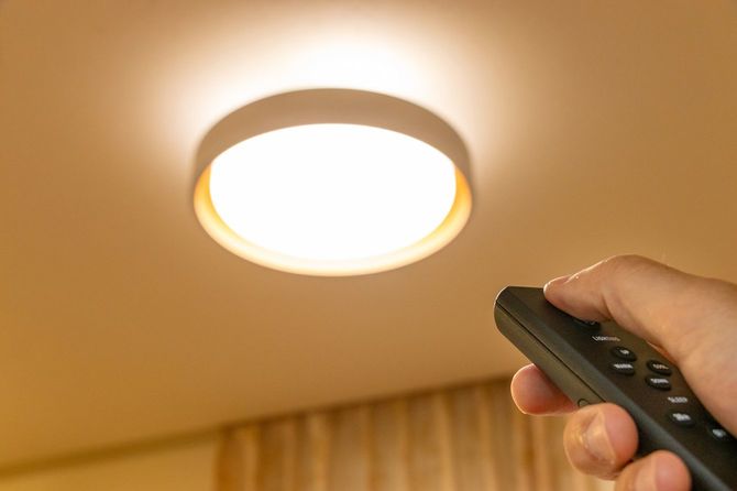 調色機能付きのライトにリモコンを向けている手元