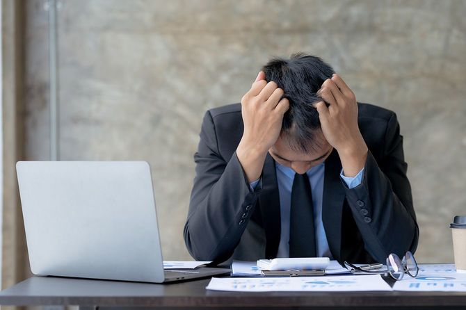 仕事中に頭を抱える男性