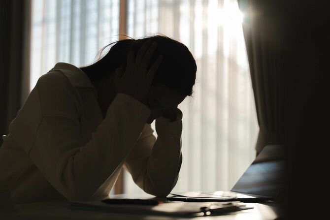 暗い部屋で落ち込む女性