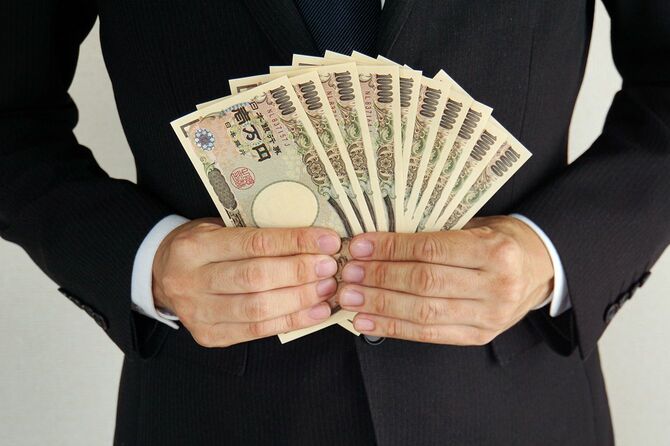 一万円札を広げる人のイメージ