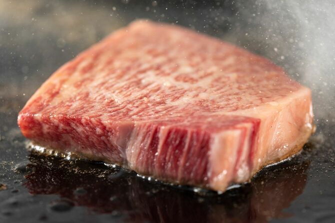 鉄板の上で焼いているサーロインステーキ肉