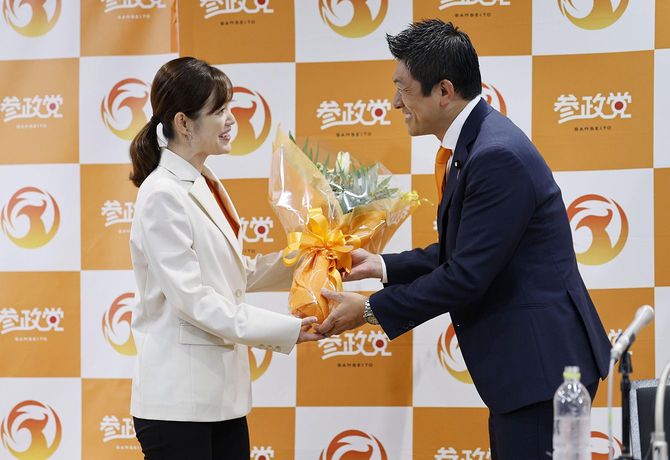 東京選挙区で当選を決めたさや氏(左)に花束を渡す参政党の神谷宗幣代表=2025年7月20日、東京都新宿区