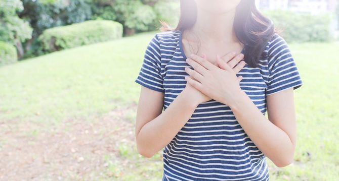 胸に手を当てる女性