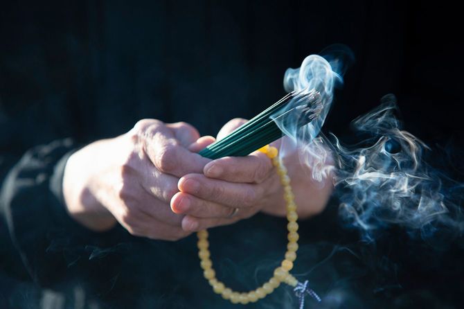 線香と数珠を持った喪服の女性