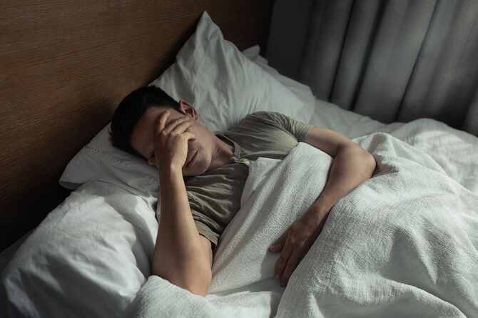うつ病に苦しむベッドの男性