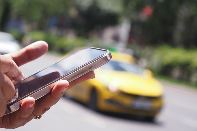 スマートフォンでタクシーを呼ぶ男性
