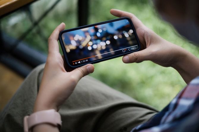 スマートフォンで動画視聴する人の手元