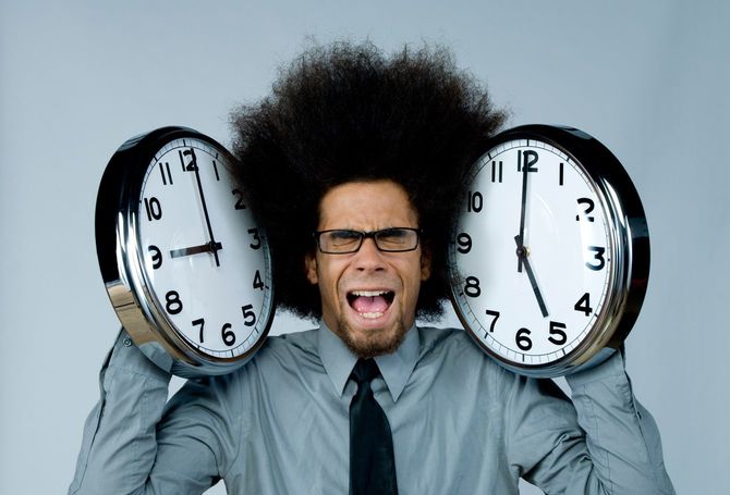 時計にはさまれた男性