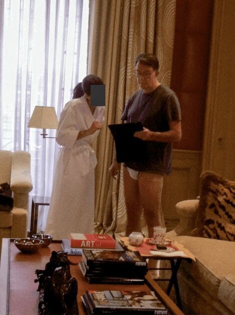 元駐米英国大使のピーター・マンデルソン氏が下着姿で、顔が伏せられた女性の隣に立っている様子