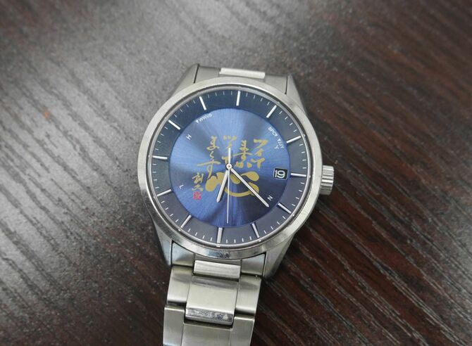 河越社長が身に着けている同社オリジナルの腕時計。「ツイてますか ツイてま～す」と書かれている