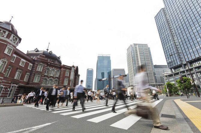 東京駅の駅前の横断歩道を渡る人々