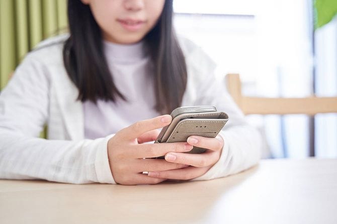 リビングでスマホを見ている女の子