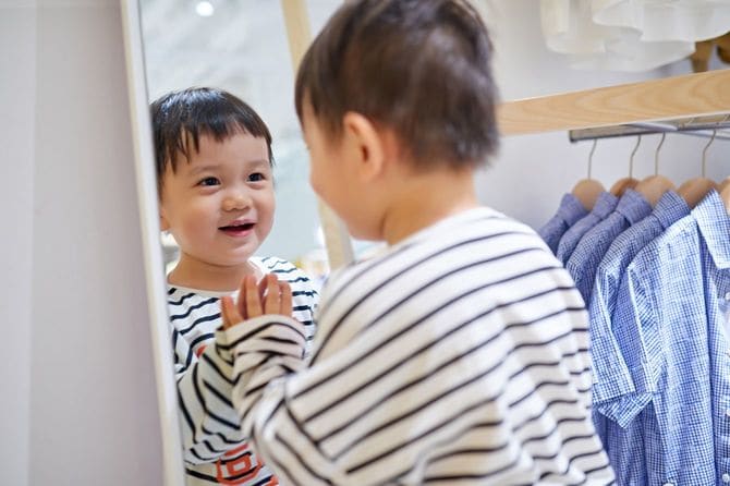 服を試着している子供