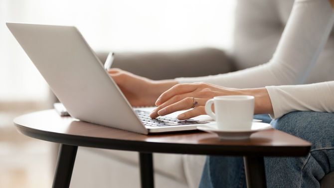 ノートを取りながら、原稿を書き進める女性