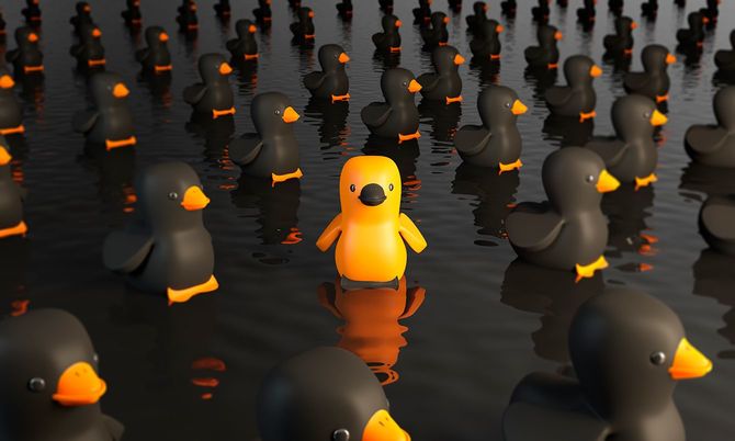 ゴム製のアヒルを群衆の中から外に立っています。