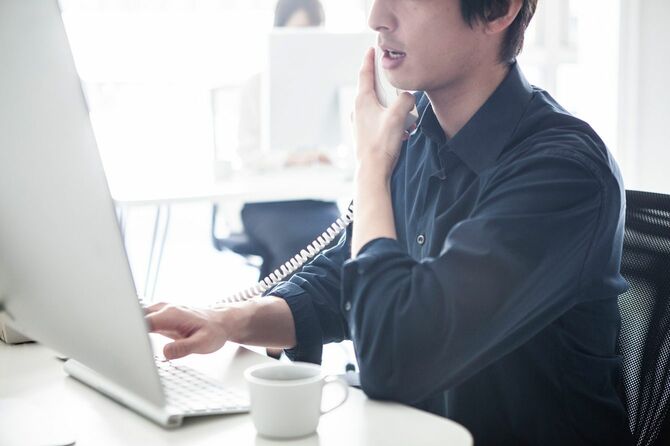 電話で顧客と会話するビジネスマン