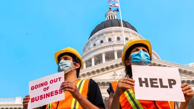 政府の建物の外で助けを求めてデモを行う建設労働者たち