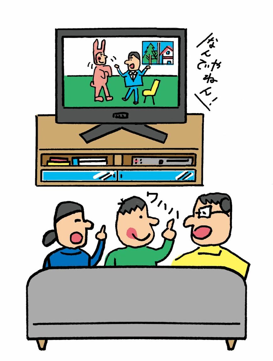 テレビで漫才を見る家族