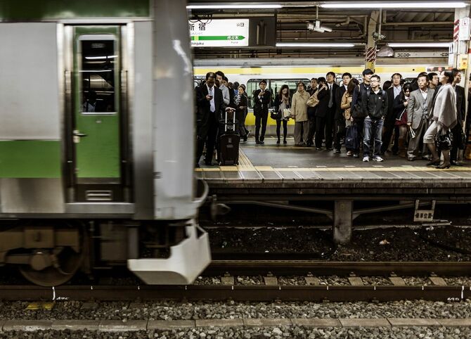 新宿駅で列車を待っている人々