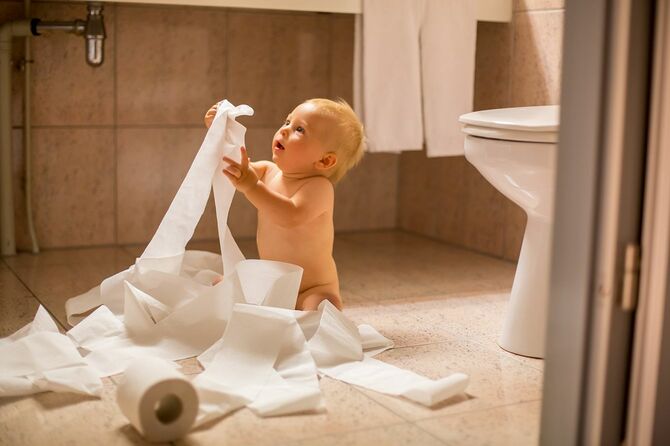 幼児男の子、トイレでトイレット ペーパーを裂く