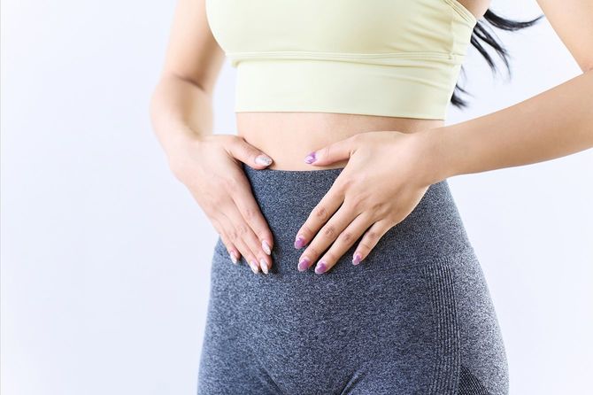 お腹をおさえる女性