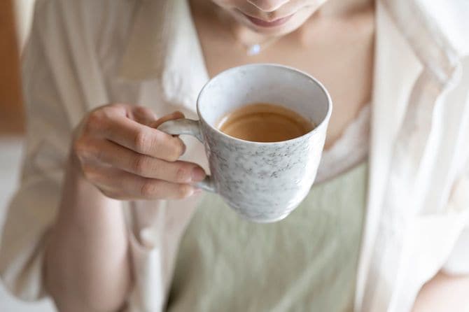 コーヒーを飲む女性の手元