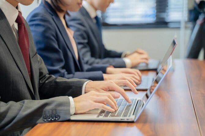 ラップトップで入力をする3人のビジネスパーソン