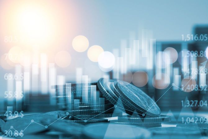 金融および投資ビジネスコンセプトのための棒グラフと積み重ねられたマネーコインの青い二重露光。