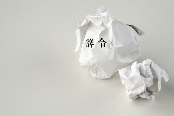 くしゃくしゃに丸められた「辞令」と書かれた紙
