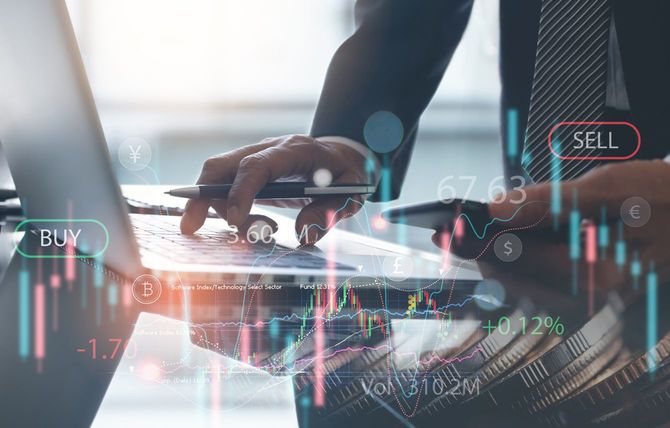 ノートパソコンで為替取引をしている男性の手元