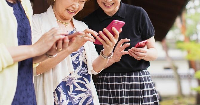 スマホを見ながら笑いあう3人の女性